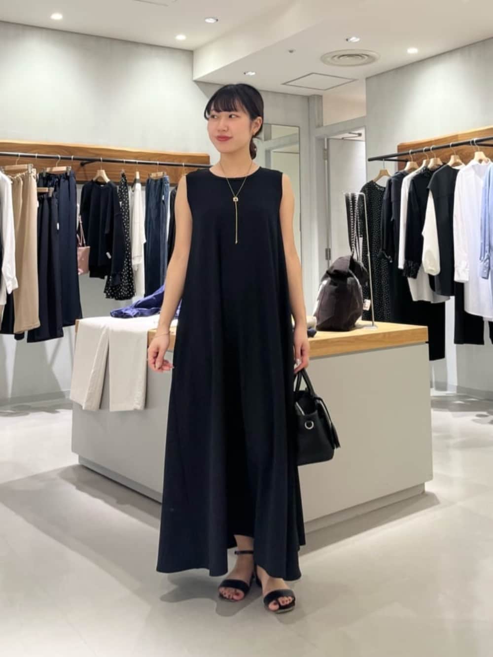 ブラック系のハンドバッグ、ブラック系のワンピースを着用したレディースの春コーディネートの3枚目の写真