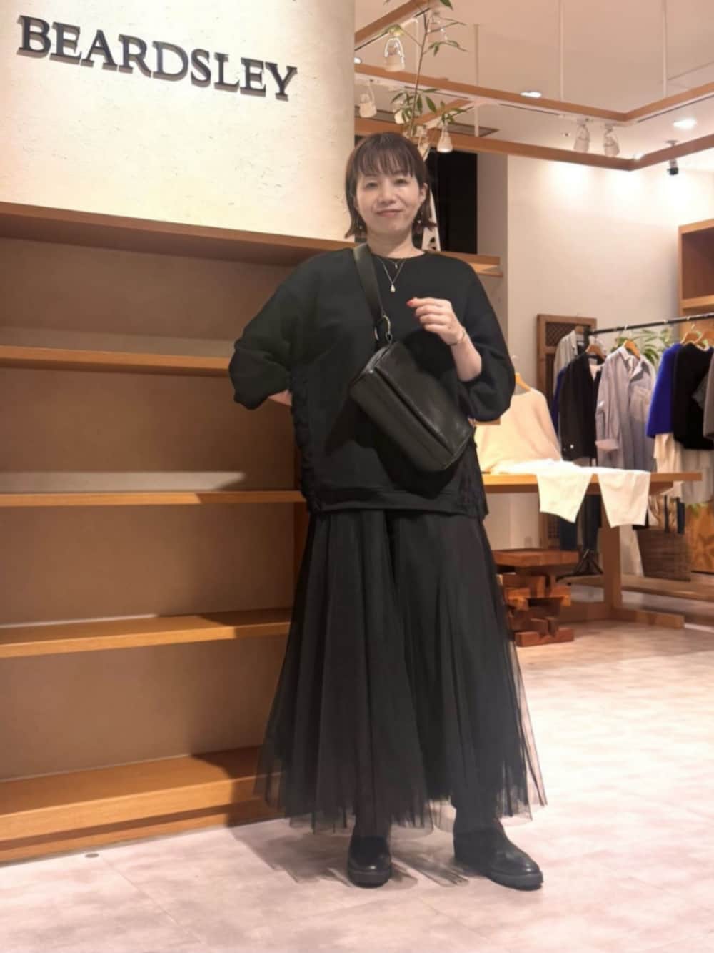 ブラック系のTシャツ/カットソー、ブラック系のスカートを着用したレディースの秋コーディネートの2枚目の写真