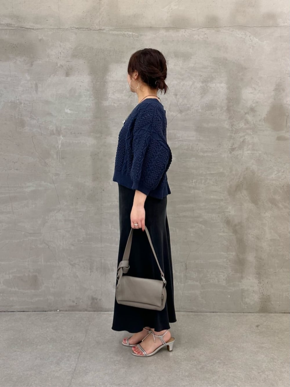 グレー系のショルダーバッグ、ブルー系のニット/セーターを着用したレディースの冬コーディネートの3枚目の写真