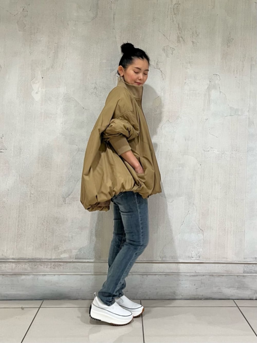 ホワイト系のスニーカー、ブルー系のデニムパンツ、イエロー系のその他アウターを着用したレディースの冬コーディネートの9枚目の写真