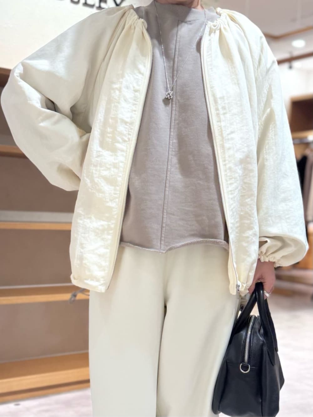 ブラック系のボストンバッグ、ブラウン系のTシャツ/カットソー、ホワイト系のその他パンツを着用したレディースの冬コーディネートの4枚目の写真