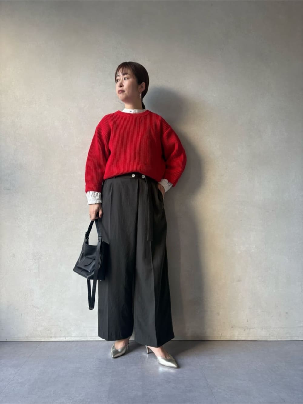 ブラック系のトートバッグ、グレー系のその他パンツ、レッド系のニット/セーターを着用したレディースの冬コーディネートの2枚目の写真