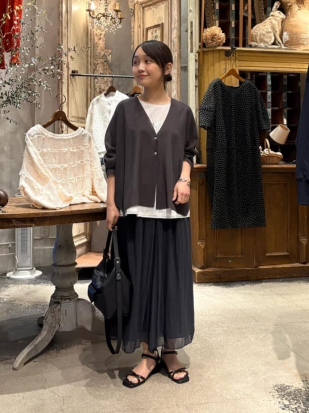 ブラック系のその他パンツ、ホワイト系のシャツ/ブラウス、グレー系のカーディガン/ボレロを着用したレディースの春コーディネートの2枚目の写真
