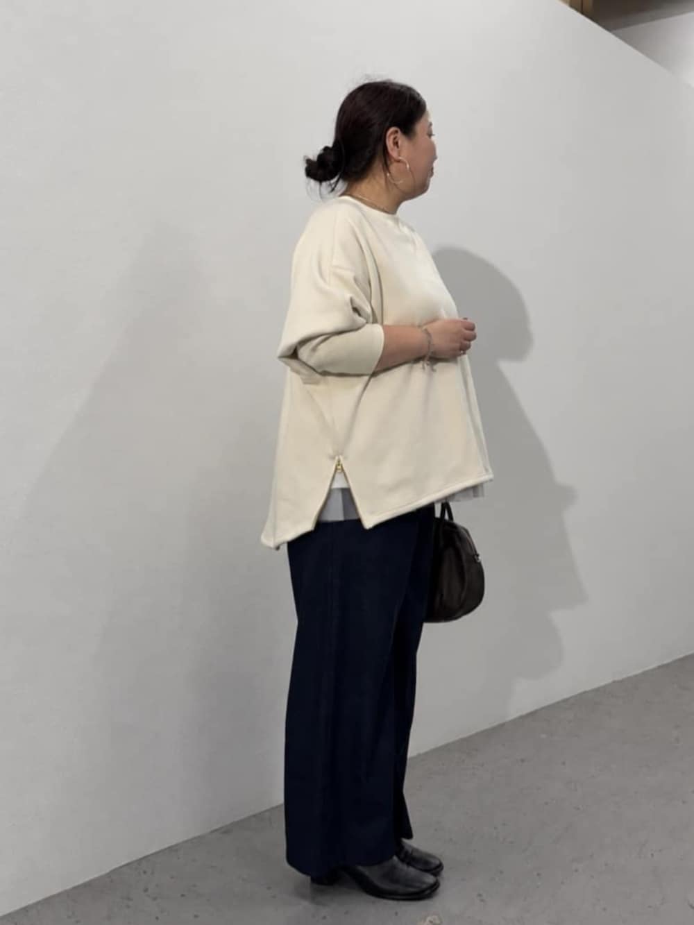 ブルー系のその他パンツ、ブラウン系のトートバッグ、ホワイト系のTシャツ/カットソーを着用したレディースの秋コーディネートの4枚目の写真