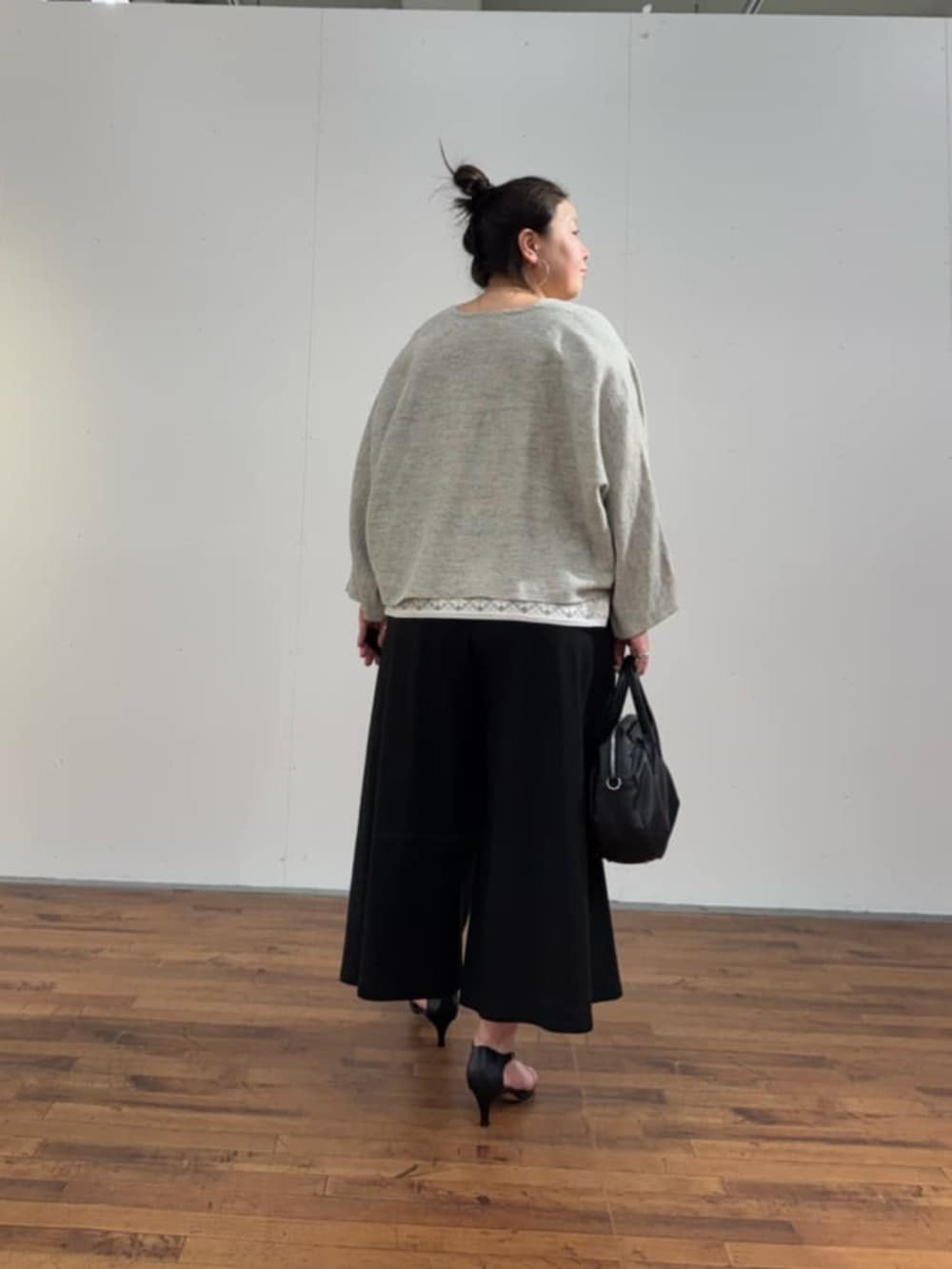 ブラック系のボストンバッグ、ホワイト系のシャツ/ブラウス、グレー系のカーディガン/ボレロを着用したレディースの春コーディネートの5枚目の写真