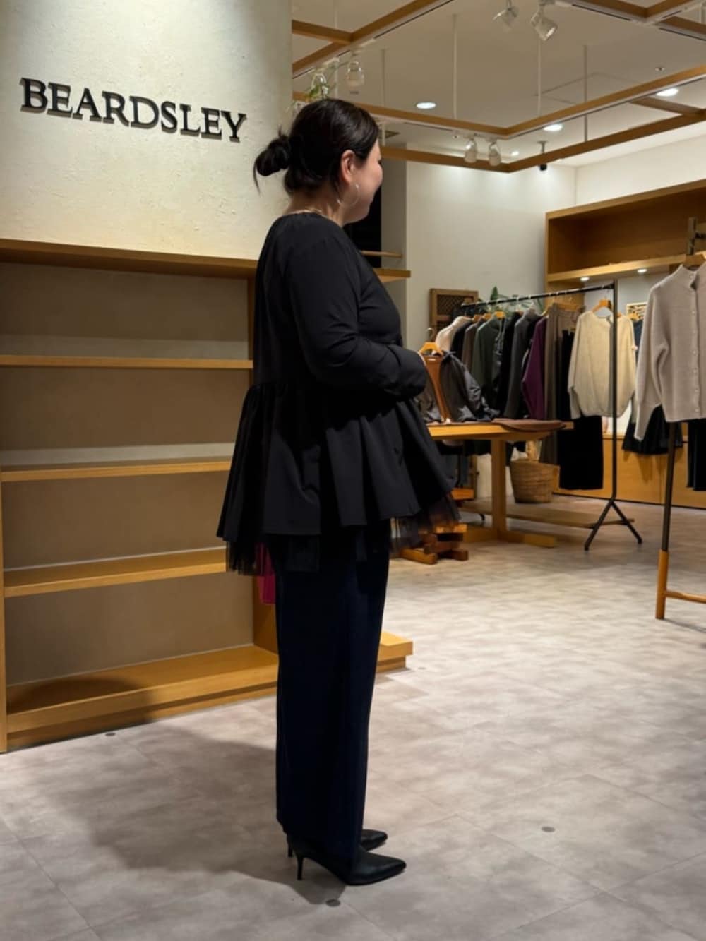 ピンク系のハンドバッグ、ブラック系のブーツ、ブラック系のブルゾンを着用したレディースの冬コーディネートの3枚目の写真