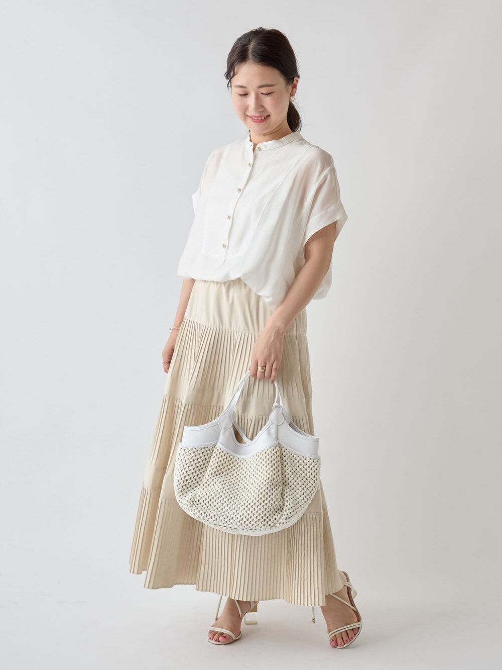 イエロー系のカーディガン/ボレロ、ホワイト系のシャツ/ブラウス、ホワイト系のスカートを着用したレディースの夏コーディネートの3枚目の写真