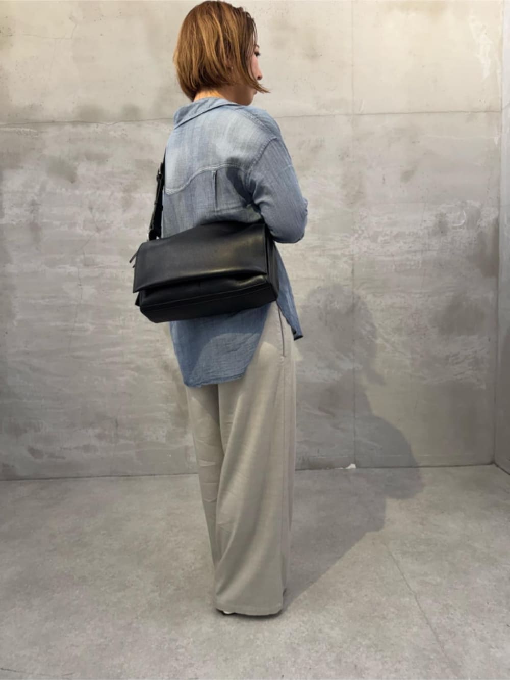 ブルー系のシャツ/ブラウス、ブラック系のショルダーバッグを着用したレディースの春コーディネートの2枚目の写真