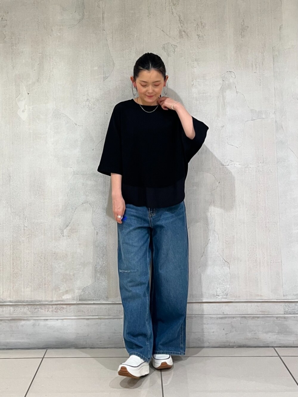 ブルー系のその他パンツ、ブラック系のTシャツ/カットソー、ホワイト系のスニーカーを着用したレディースの春コーディネートの2枚目の写真