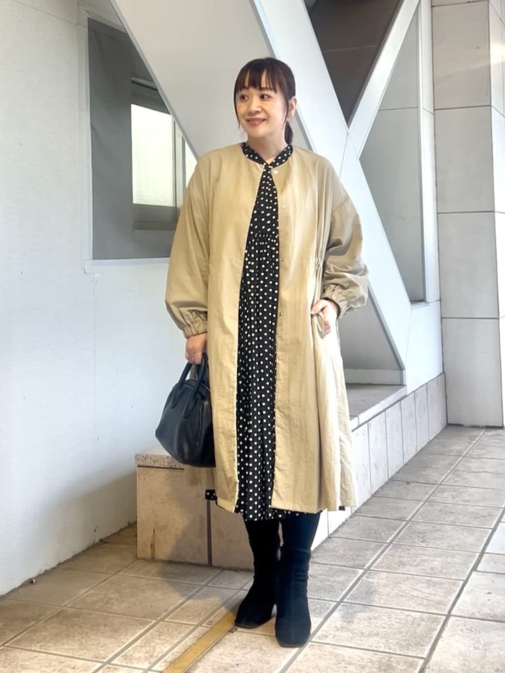 ベージュ系のその他アウター、ブラック系のワンピースを着用したレディースの冬コーディネートの7枚目の写真