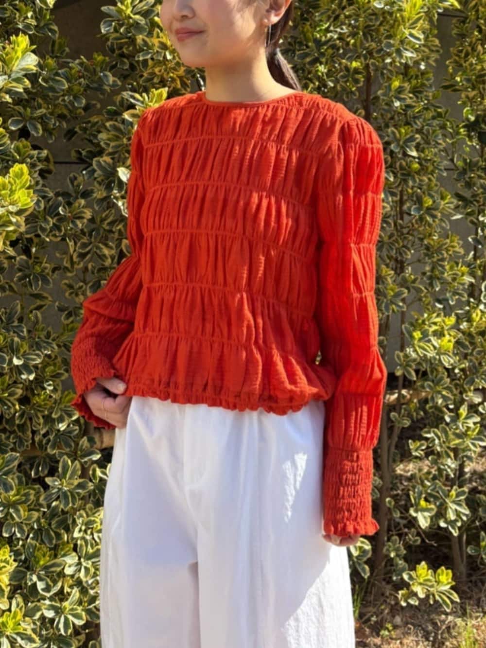 オレンジ系のシャツ/ブラウス、ホワイト系のその他パンツを着用したレディースの春コーディネートの6枚目の写真