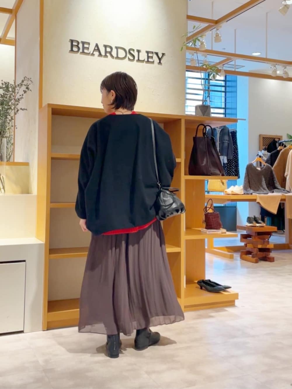 ブラウン系のその他パンツ、ブラック系のノーカラーコート、ブラック系のブーツを着用したレディースの冬コーディネートの4枚目の写真