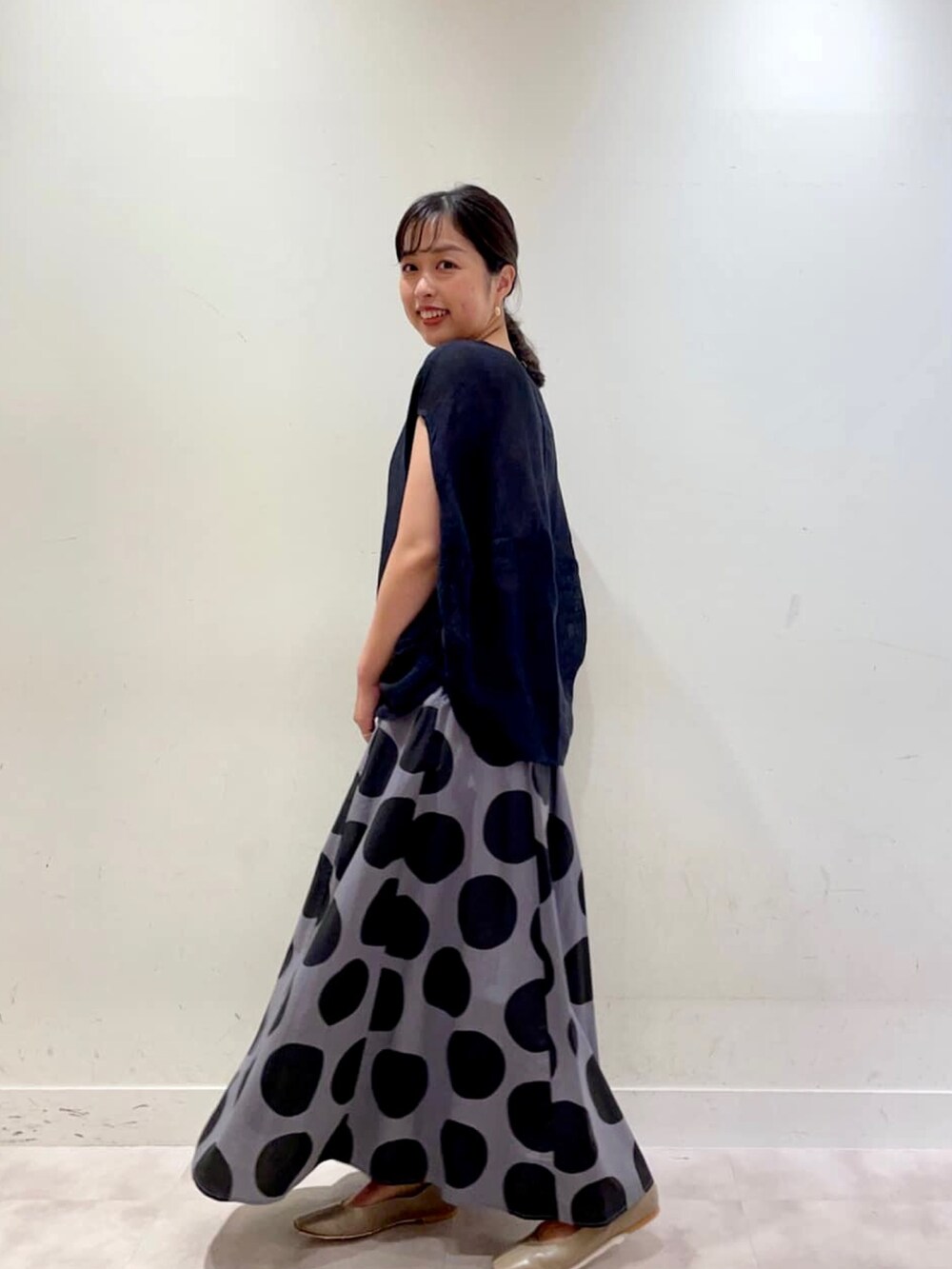 ブラック系のシャツ/ブラウス、グレー系のスカートを着用したレディースの夏コーディネートの2枚目の写真