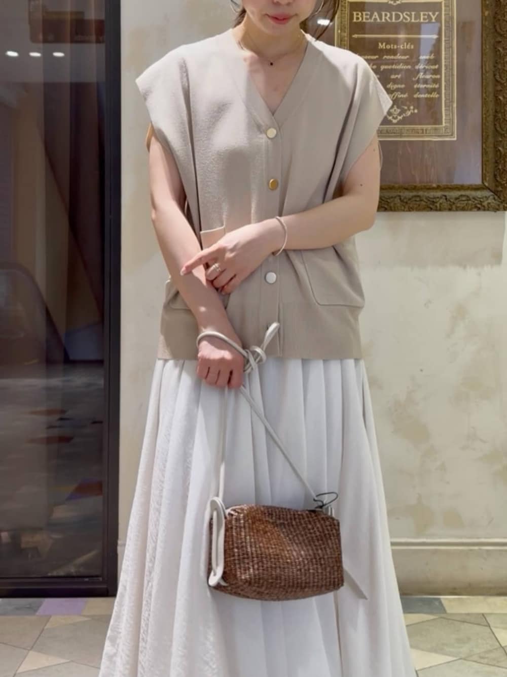 ホワイト系のスカート、ベージュ系のカーディガン/ボレロを着用したレディースの春コーディネートの7枚目の写真