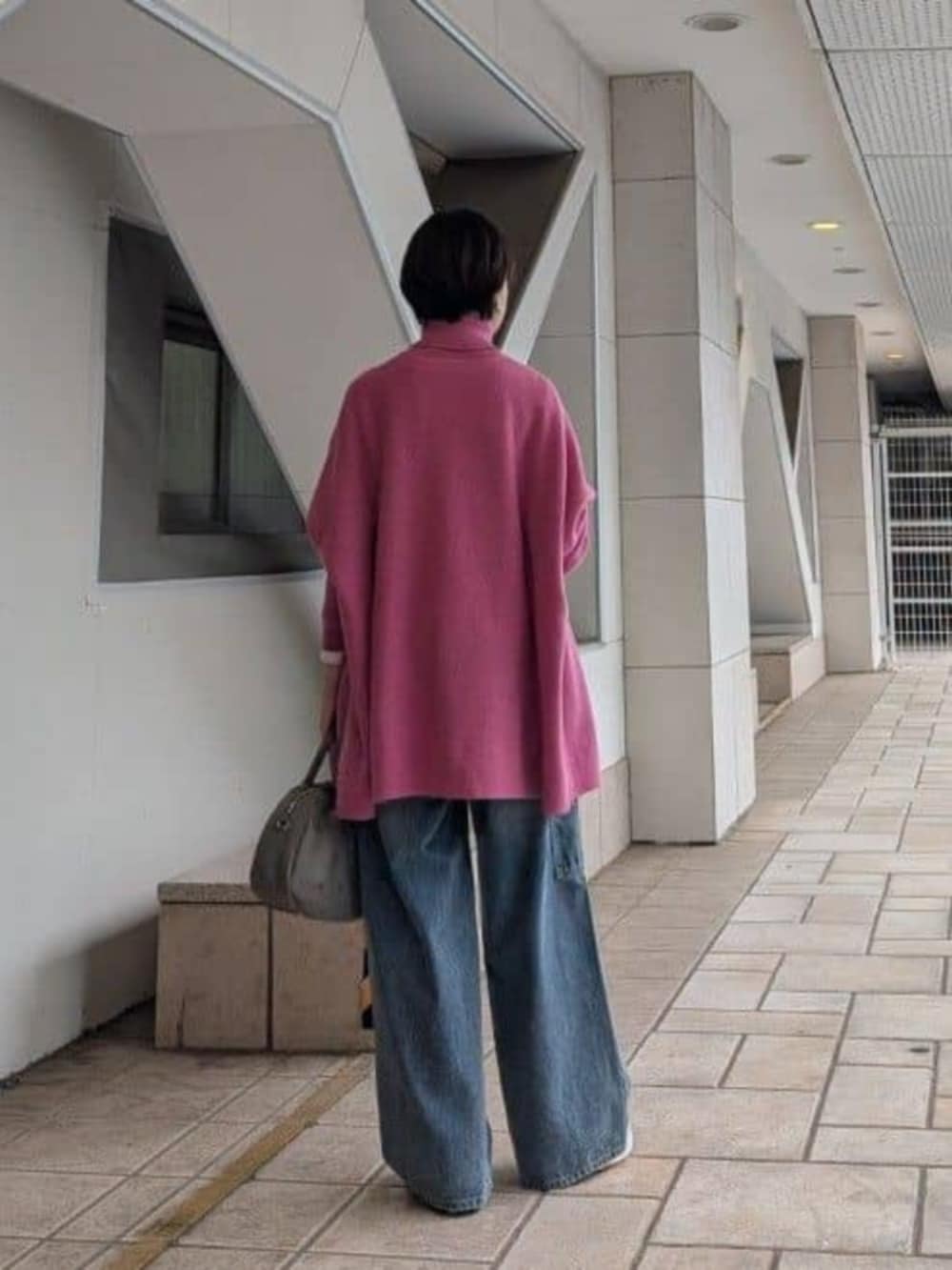 ホワイト系のスニーカー、ブルー系のデニムパンツ、グレー系のトートバッグを着用したレディースの秋コーディネートの4枚目の写真