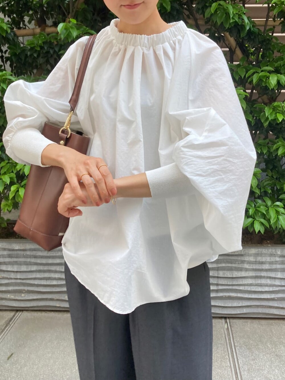 ホワイト系のシャツ/ブラウス、グレー系のその他パンツ、ブラウン系のトートバッグを着用したレディースの春コーディネートの2枚目の写真