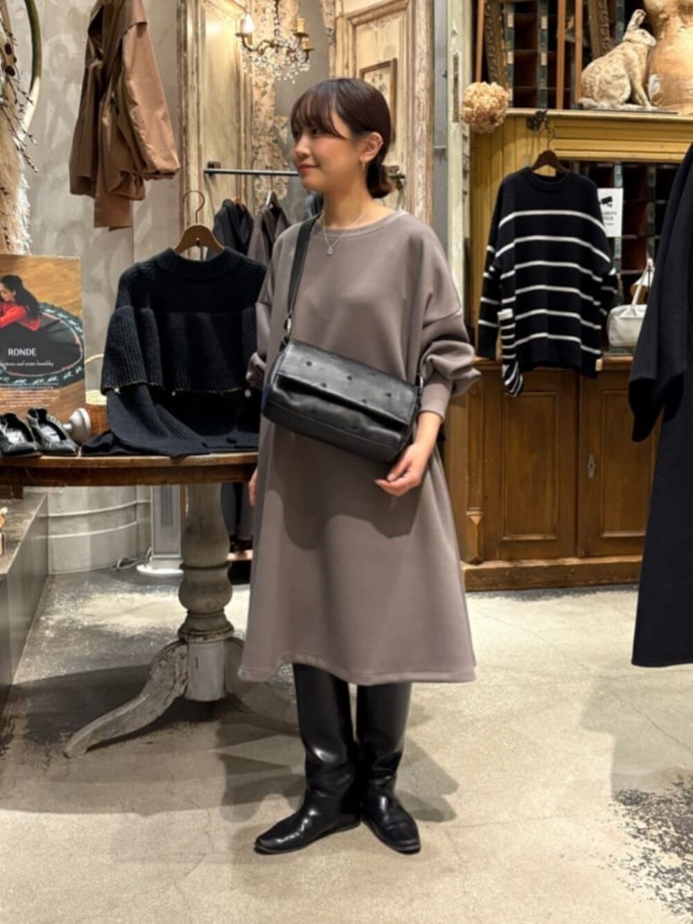 ブラウン系のワンピース、ブラック系のショルダーバッグ、シルバー系のネックレスを着用したレディースの冬コーディネートの3枚目の写真