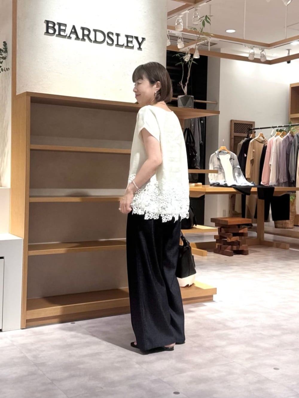 ブルー系のその他パンツ、ブラック系のトートバッグ、ホワイト系のシャツ/ブラウスを着用したレディースの春コーディネートの8枚目の写真