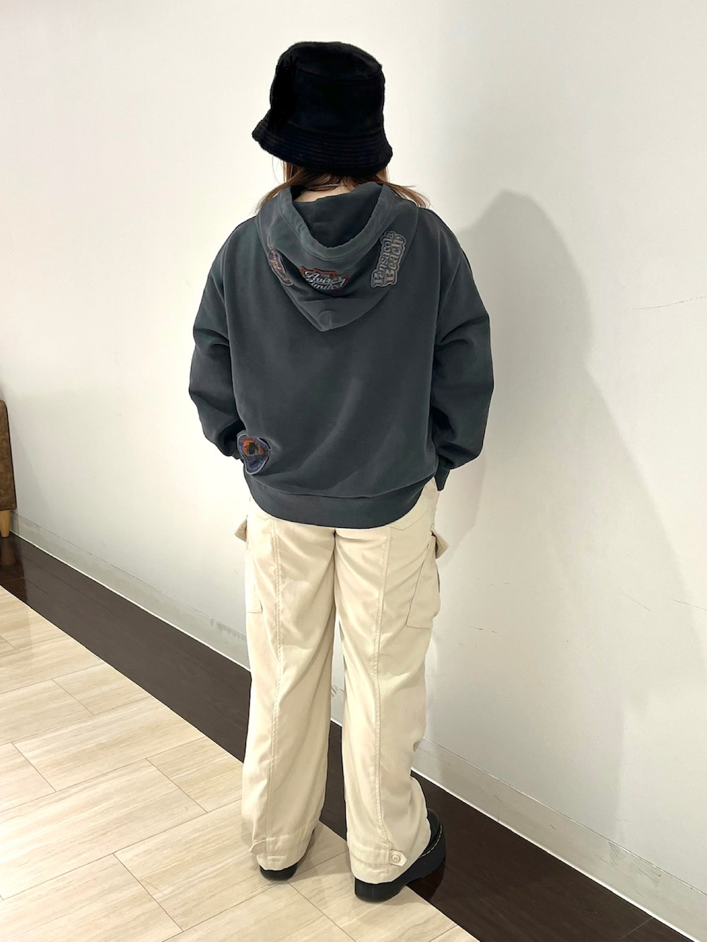 ブラック系のパーカー、ホワイト系のカーゴパンツ、ブラック系のハットを着用したレディースの冬コーディネートの2枚目の写真