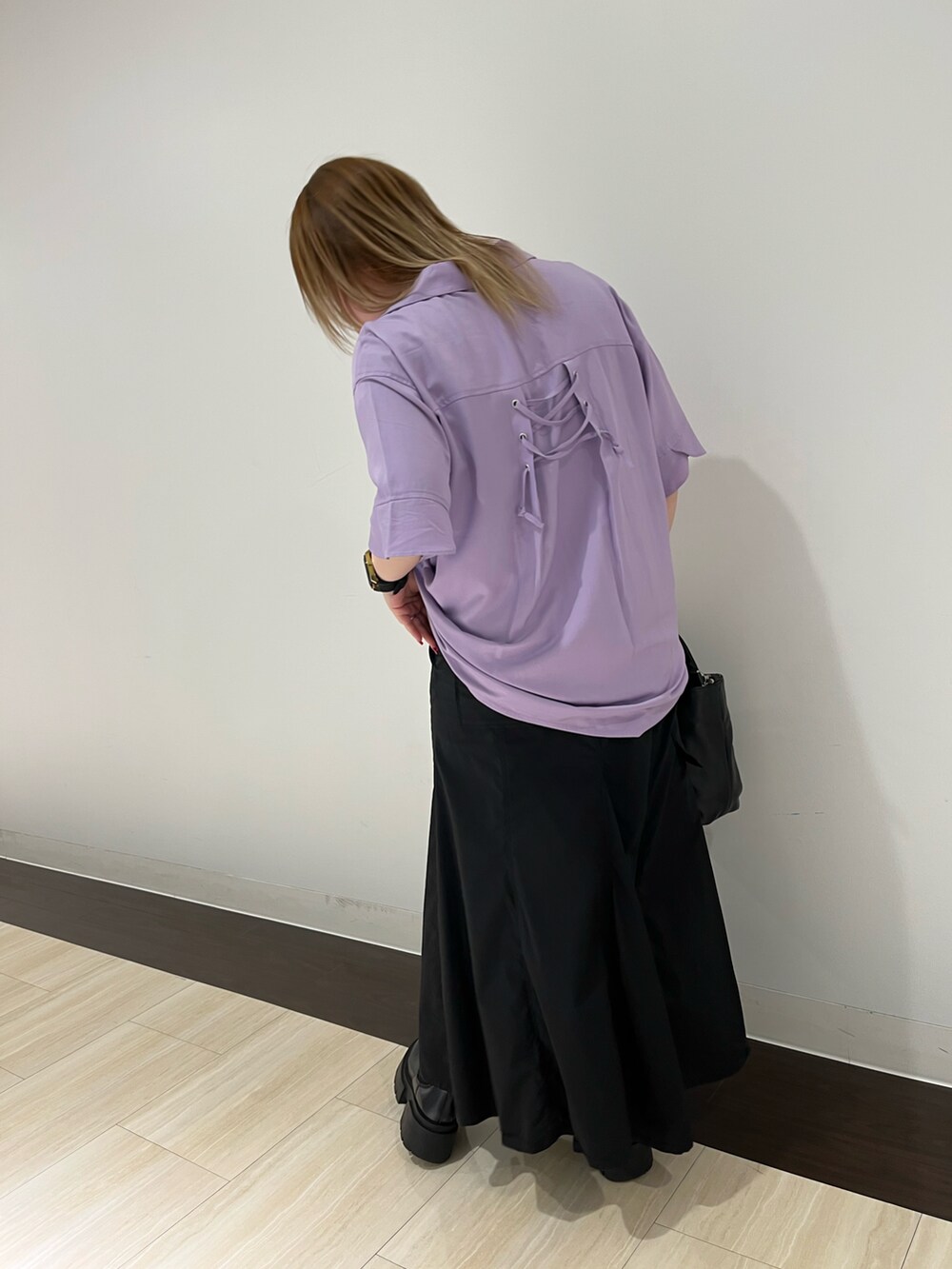 パープル系のシャツ/ブラウス、グリーン系のスカート、ブラック系のトートバッグを着用したレディースの春コーディネートの2枚目の写真