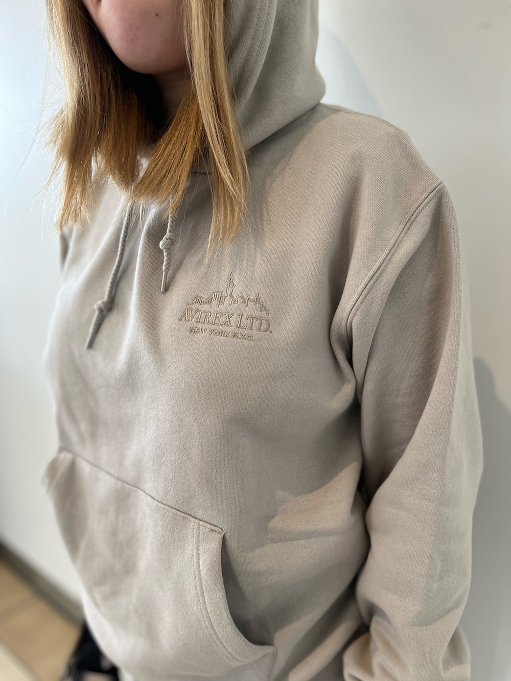 ベージュ系のパーカー、ベージュ系のスカート、ブラウン系のトートバッグを着用したレディースの秋コーディネートの4枚目の写真