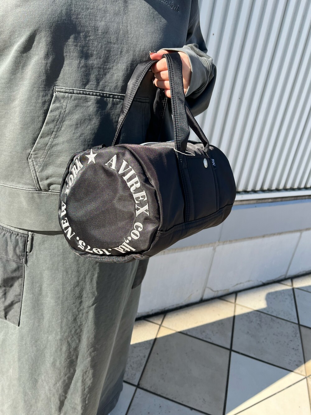 グレー系のパーカー、グレー系のスカート、ブラック系のボストンバッグを着用したレディースの冬コーディネートの5枚目の写真