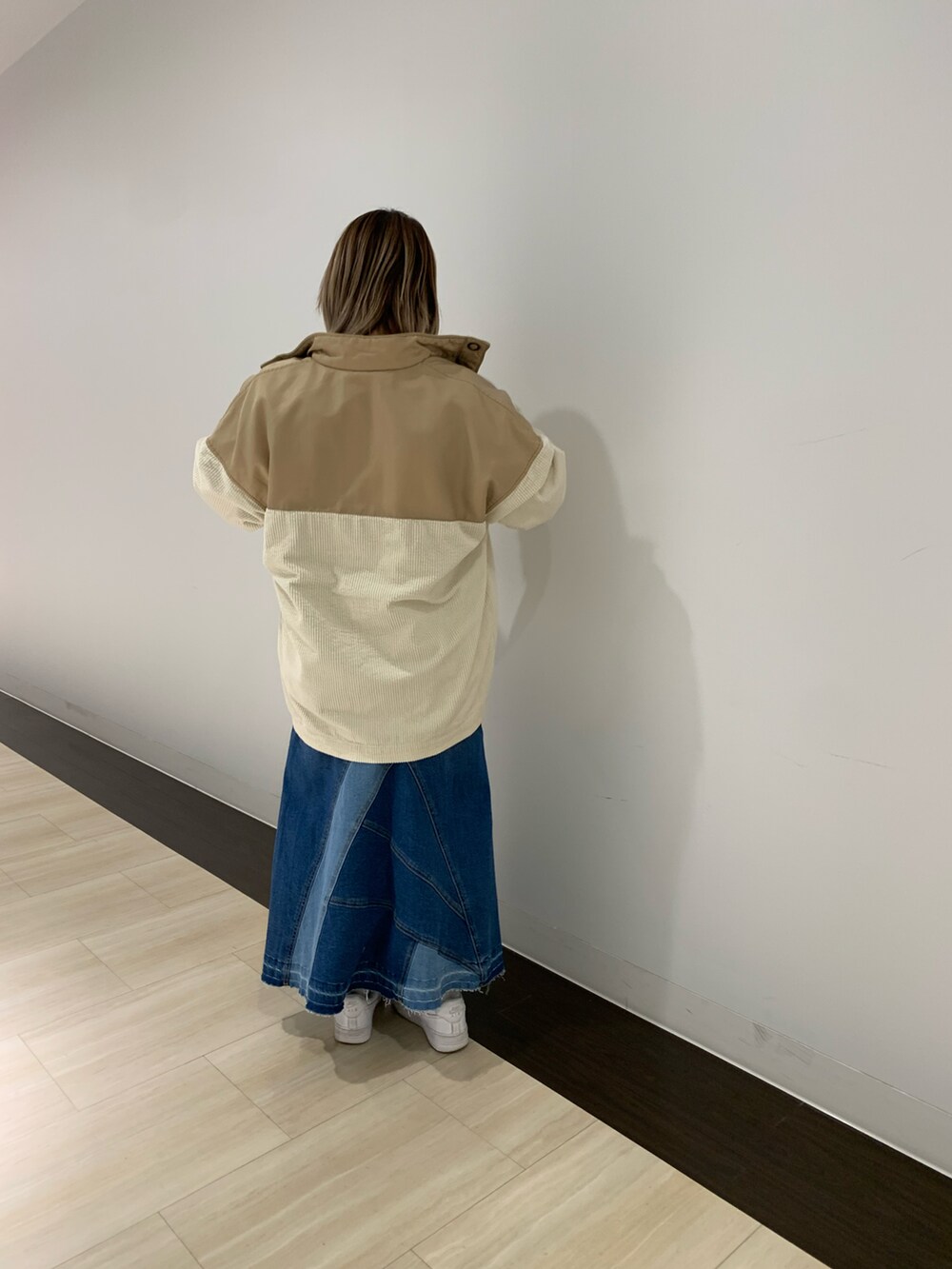 ベージュ系のブルゾン、その他のスウェット、ブルー系のデニムスカートを着用したレディースの冬コーディネートの2枚目の写真