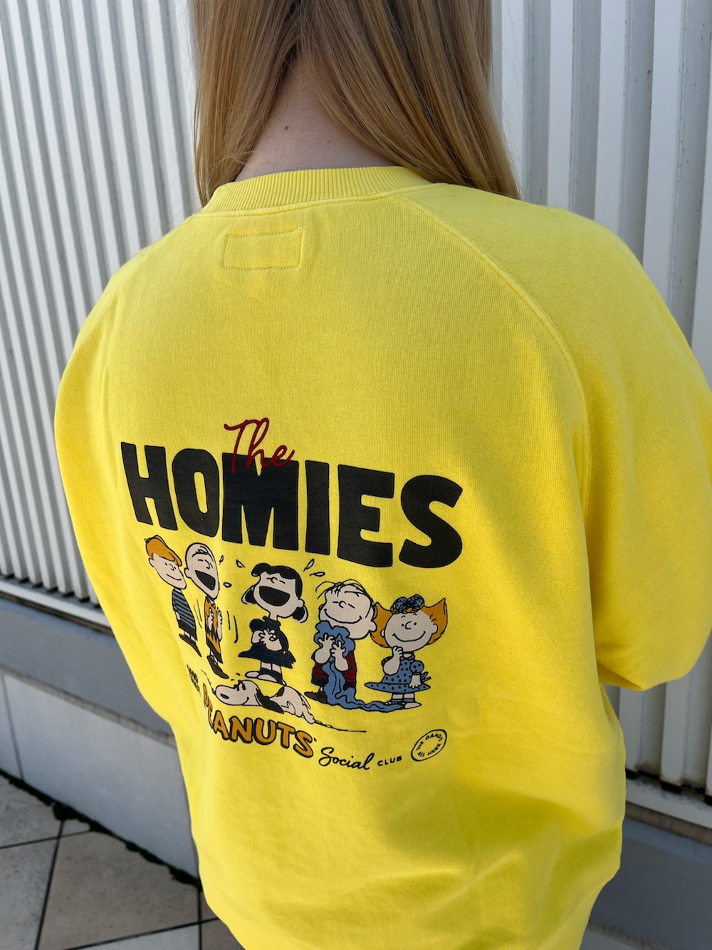 イエロー系のスウェット、ホワイト系のトートバッグ、ブラック系のデニムパンツを着用したレディースの秋コーディネートの3枚目の写真