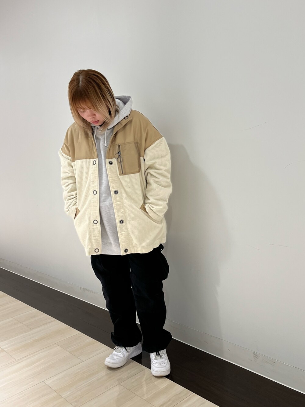 グレー系のパーカー、ベージュ系のブルゾン、ブラック系のカーゴパンツを着用したレディースの冬コーディネートの2枚目の写真
