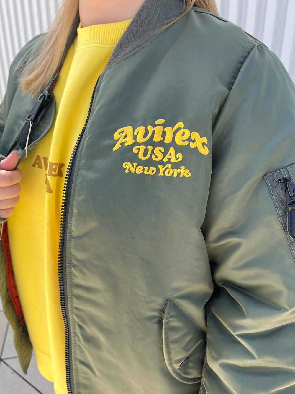 グリーン系のMA-1、イエロー系のスウェット、ブラック系のデニムパンツを着用したレディースの秋コーディネートの4枚目の写真