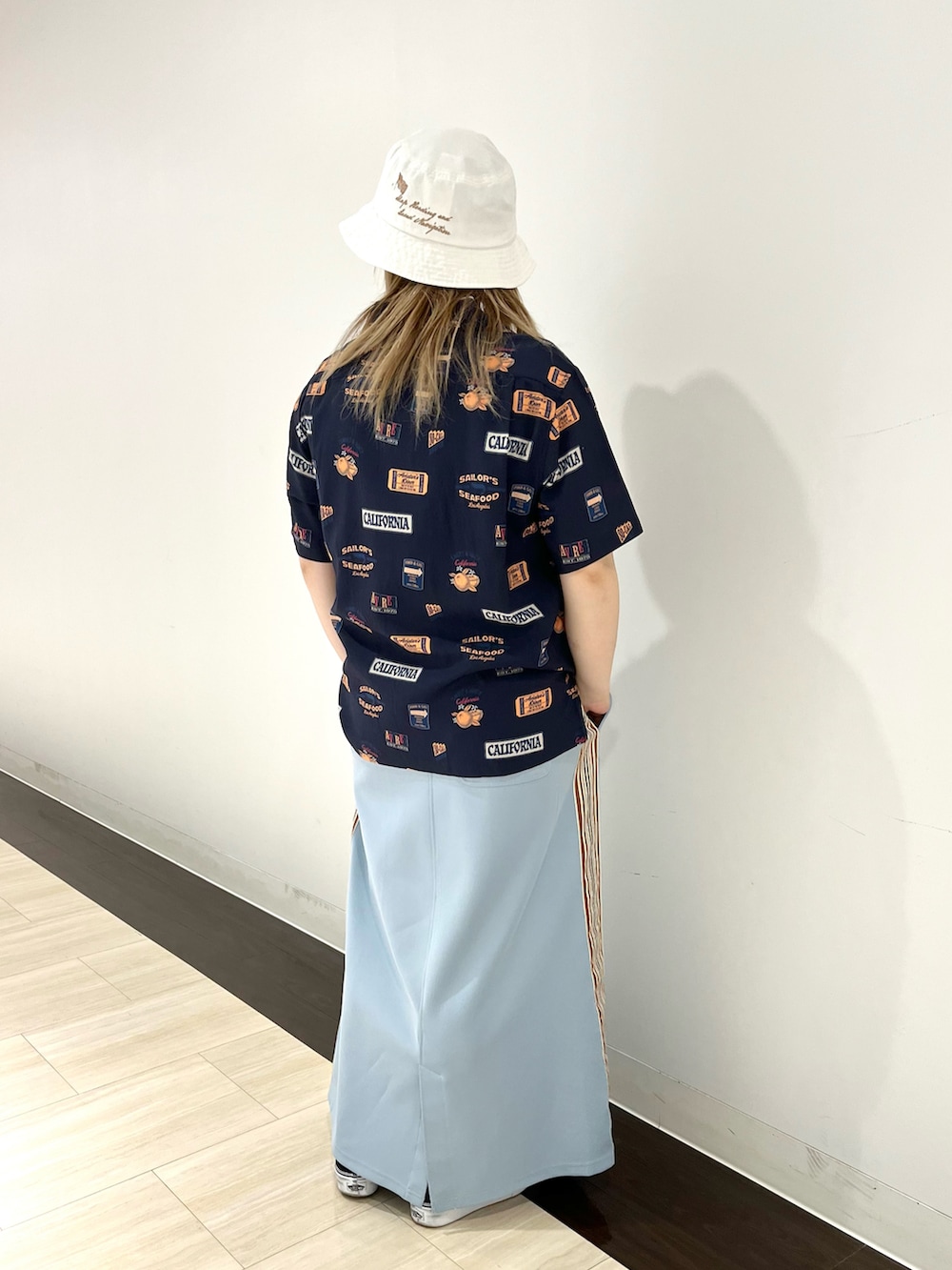 ブルー系のシャツ/ブラウス、ブルー系のスカート、ホワイト系のハットを着用したレディースの夏コーディネートの2枚目の写真