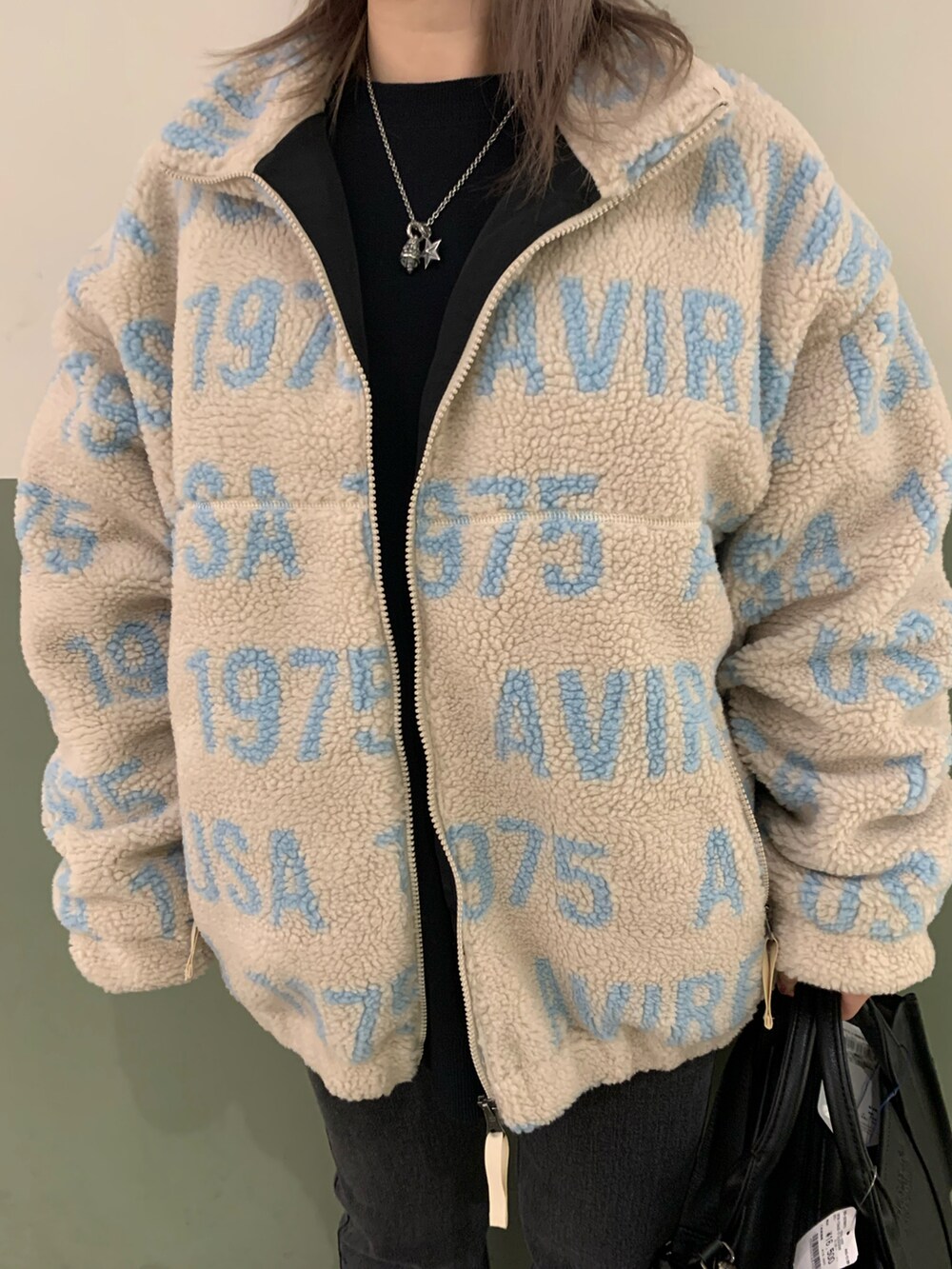 ブラック系のスウェット、ベージュ系のブルゾン、ブラック系のデニムパンツを着用したレディースの秋コーディネートの3枚目の写真