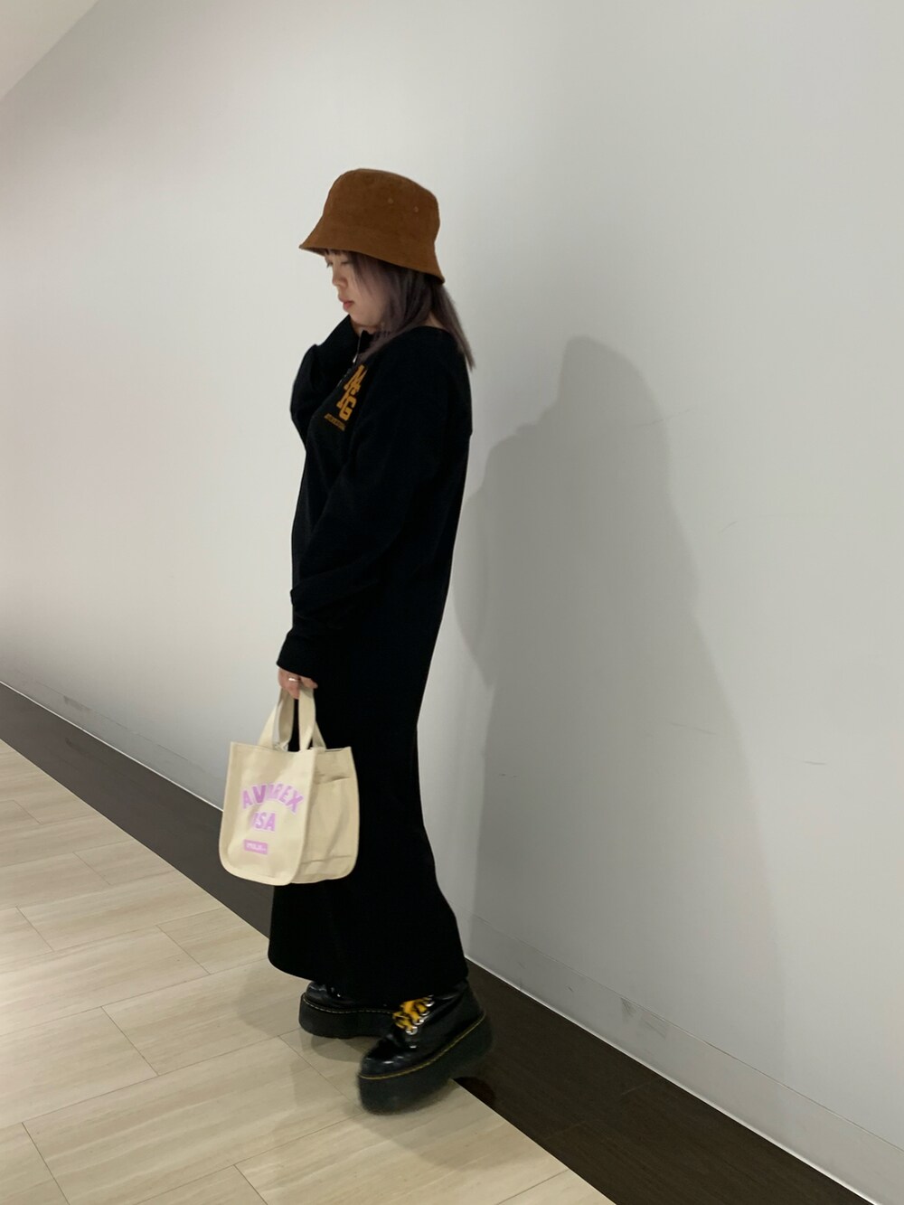 ブラック系のワンピース、ホワイト系のバッグ、ベージュ系のハットを着用したレディースの秋コーディネートの2枚目の写真