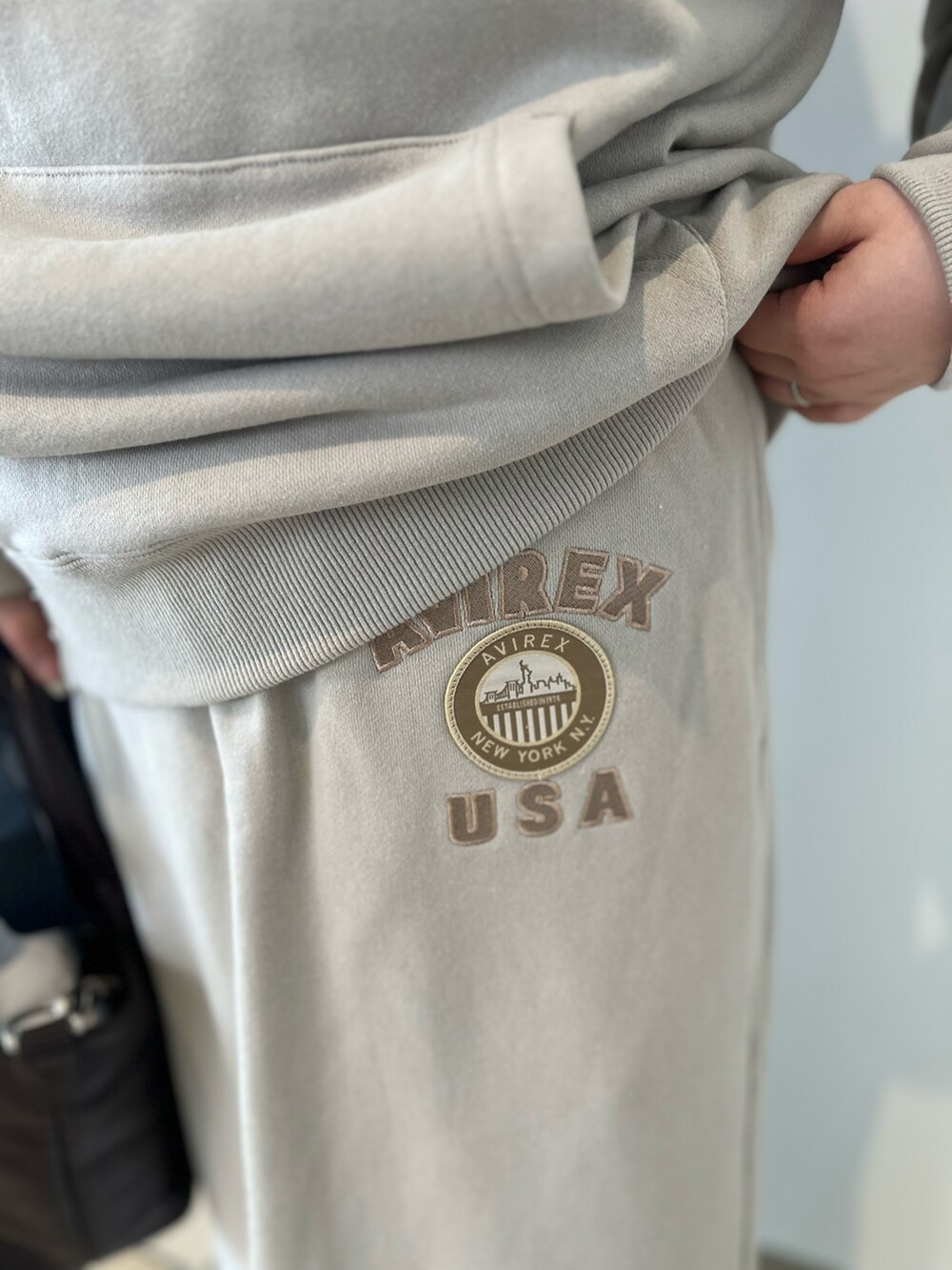 ベージュ系のパーカー、ベージュ系のスカート、ブラウン系のトートバッグを着用したレディースの秋コーディネートの5枚目の写真