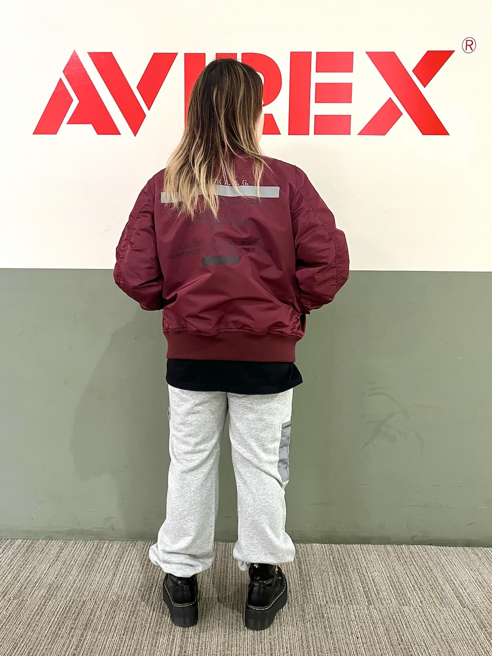 イエロー系のTシャツ/カットソー、レッド系のMA-1、グレー系のスウェットパンツを着用したレディースの夏コーディネートの3枚目の写真