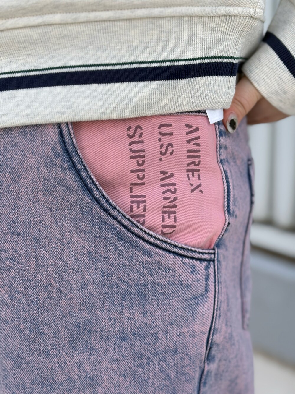 ベージュ系のスウェット、ピンク系のデニムパンツ、ブラック系のボストンバッグを着用したレディースの冬コーディネートの4枚目の写真