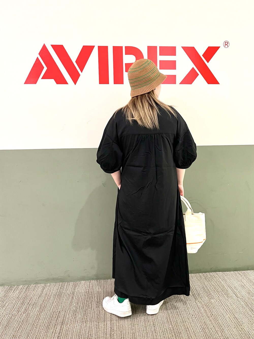 ブラック系のワンピース、ホワイト系のトートバッグ、ブラウン系のハットを着用したレディースの夏コーディネートの2枚目の写真