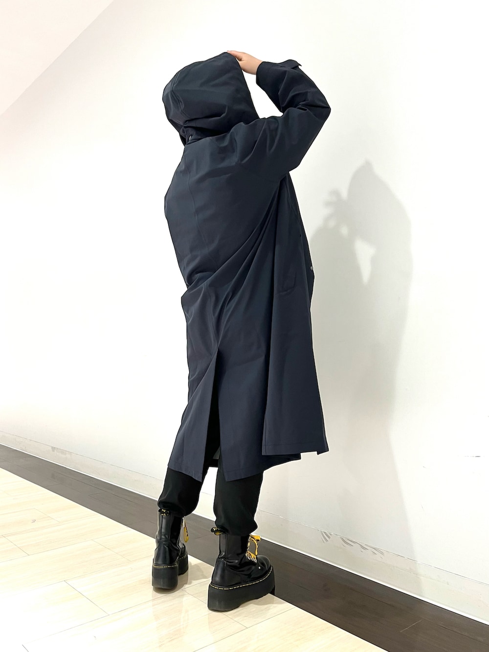 ブルー系のステンカラーコート、ブラック系のTシャツ/カットソー、グリーン系のショルダーバッグを着用したレディースの夏コーディネートの3枚目の写真