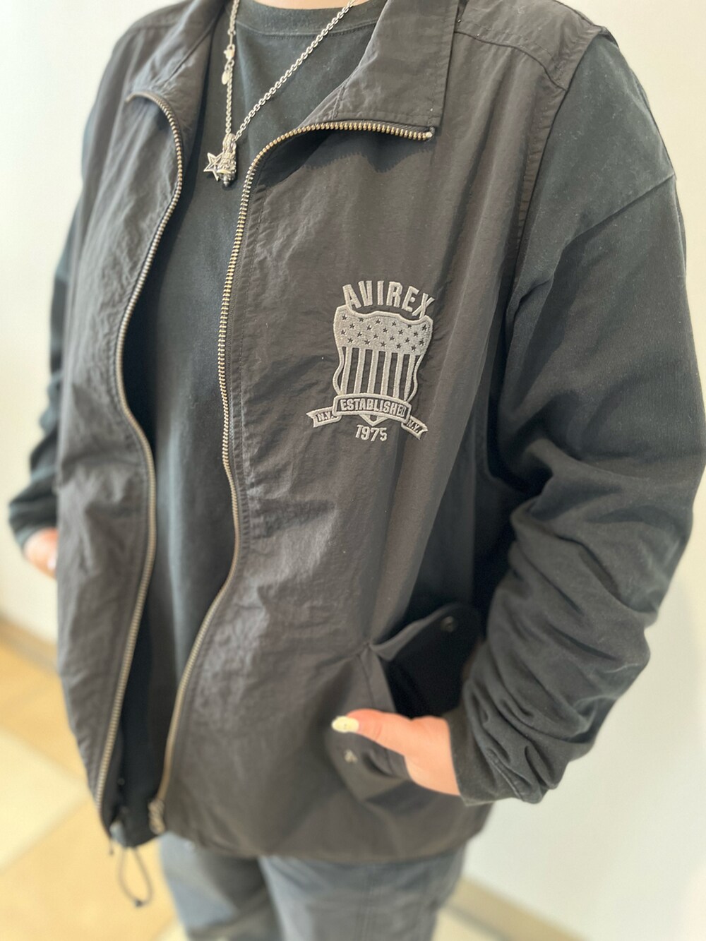 ブラック系のTシャツ/カットソー、ブラック系のベスト、ブラック系のカーゴパンツを着用したレディースの秋コーディネートの4枚目の写真