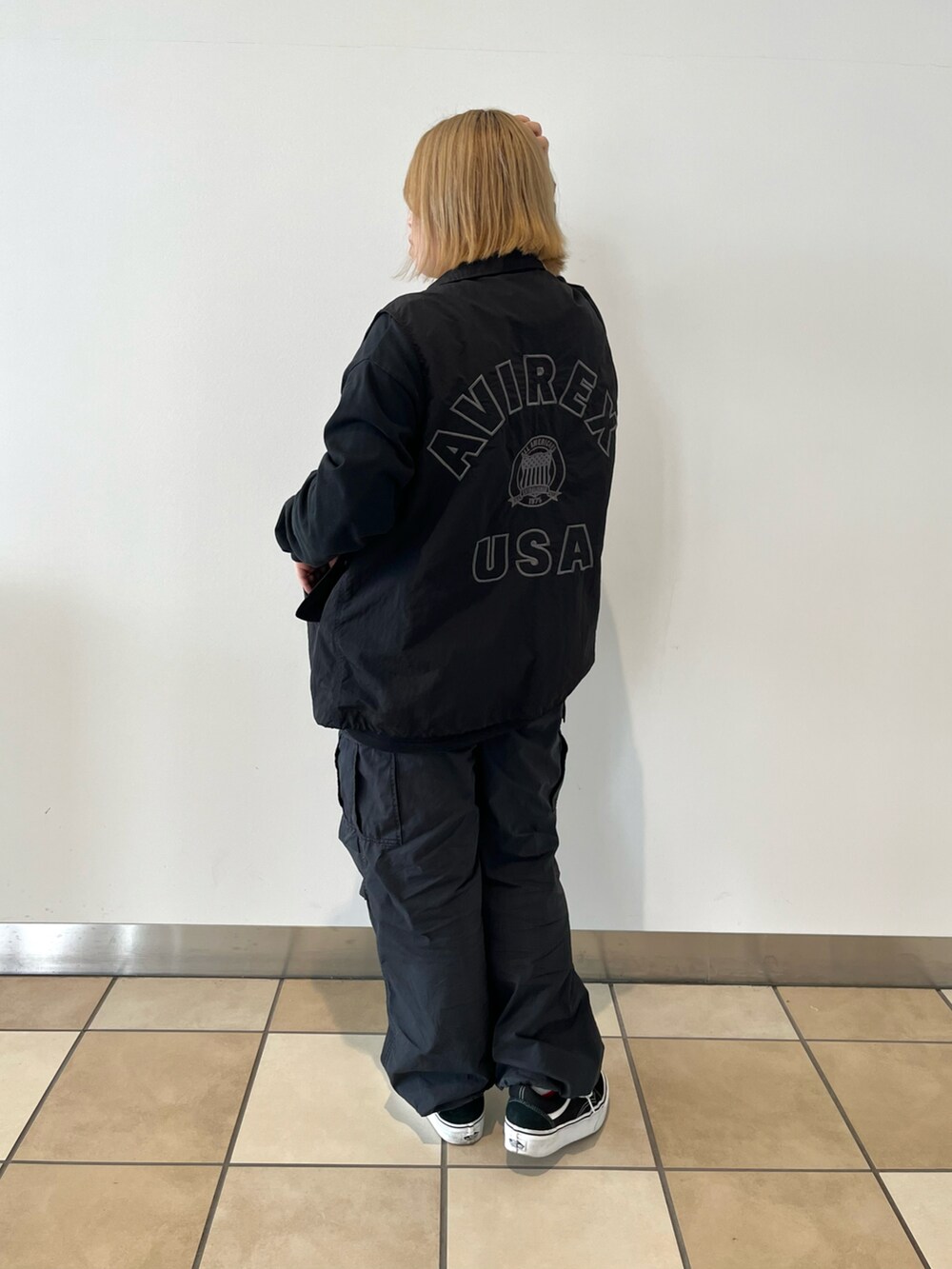 ブラック系のTシャツ/カットソー、ブラック系のベスト、ブラック系のカーゴパンツを着用したレディースの秋コーディネートの2枚目の写真