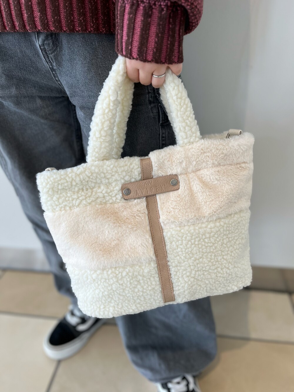 ピンク系のニット/セーター、ブルー系のデニムパンツ、ホワイト系のトートバッグを着用したレディースの秋コーディネートの3枚目の写真