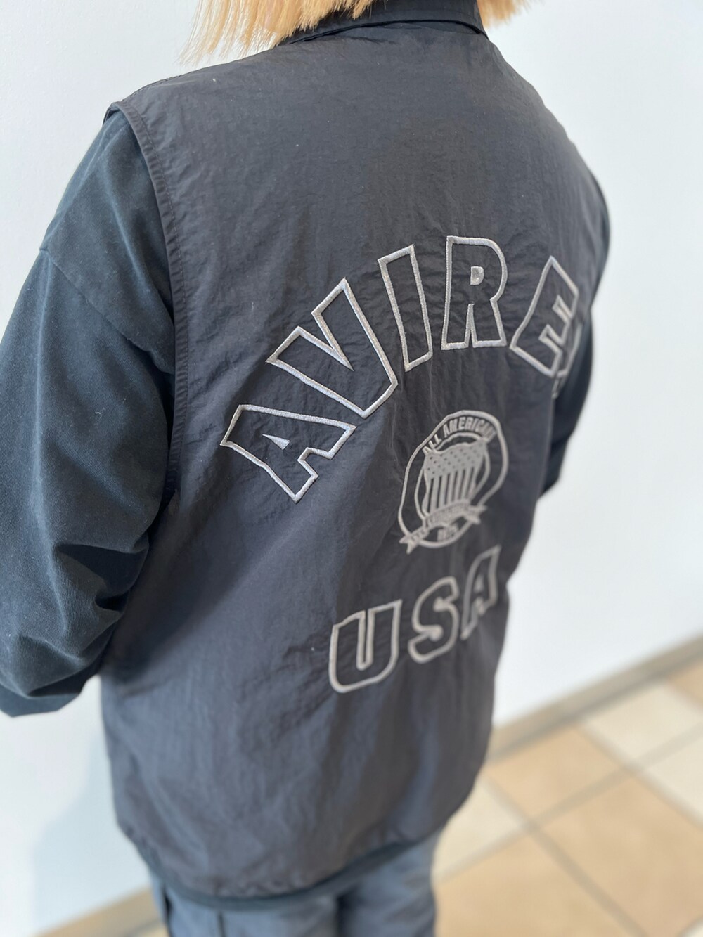 ブラック系のTシャツ/カットソー、ブラック系のベスト、ブラック系のカーゴパンツを着用したレディースの秋コーディネートの5枚目の写真