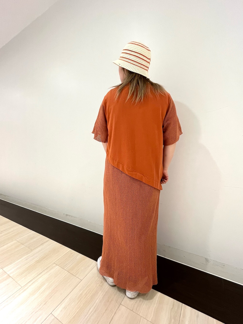 レッド系のワンピース、ホワイト系のタンクトップ、ホワイト系のハットを着用したレディースの春コーディネートの2枚目の写真