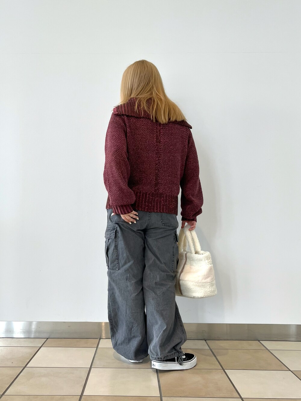 ピンク系のニット/セーター、ブルー系のデニムパンツ、ホワイト系のトートバッグを着用したレディースの秋コーディネートの2枚目の写真