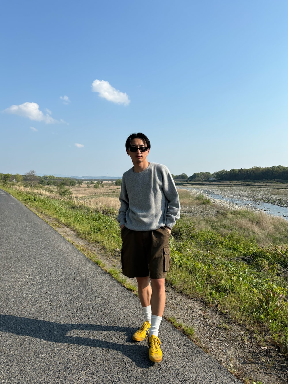 ブラウン系のその他パンツ、イエロー系のスニーカー、グレー系のニット/セーターを着用したメンズの春コーディネートの2枚目の写真