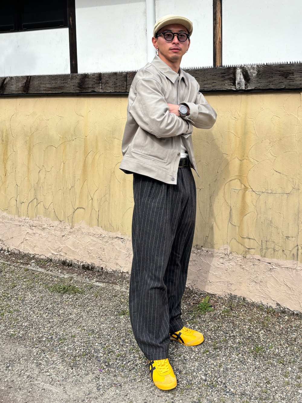 グレー系のカバーオール、イエロー系のスニーカー、ブラック系のスラックスを着用したメンズの春コーディネートの2枚目の写真