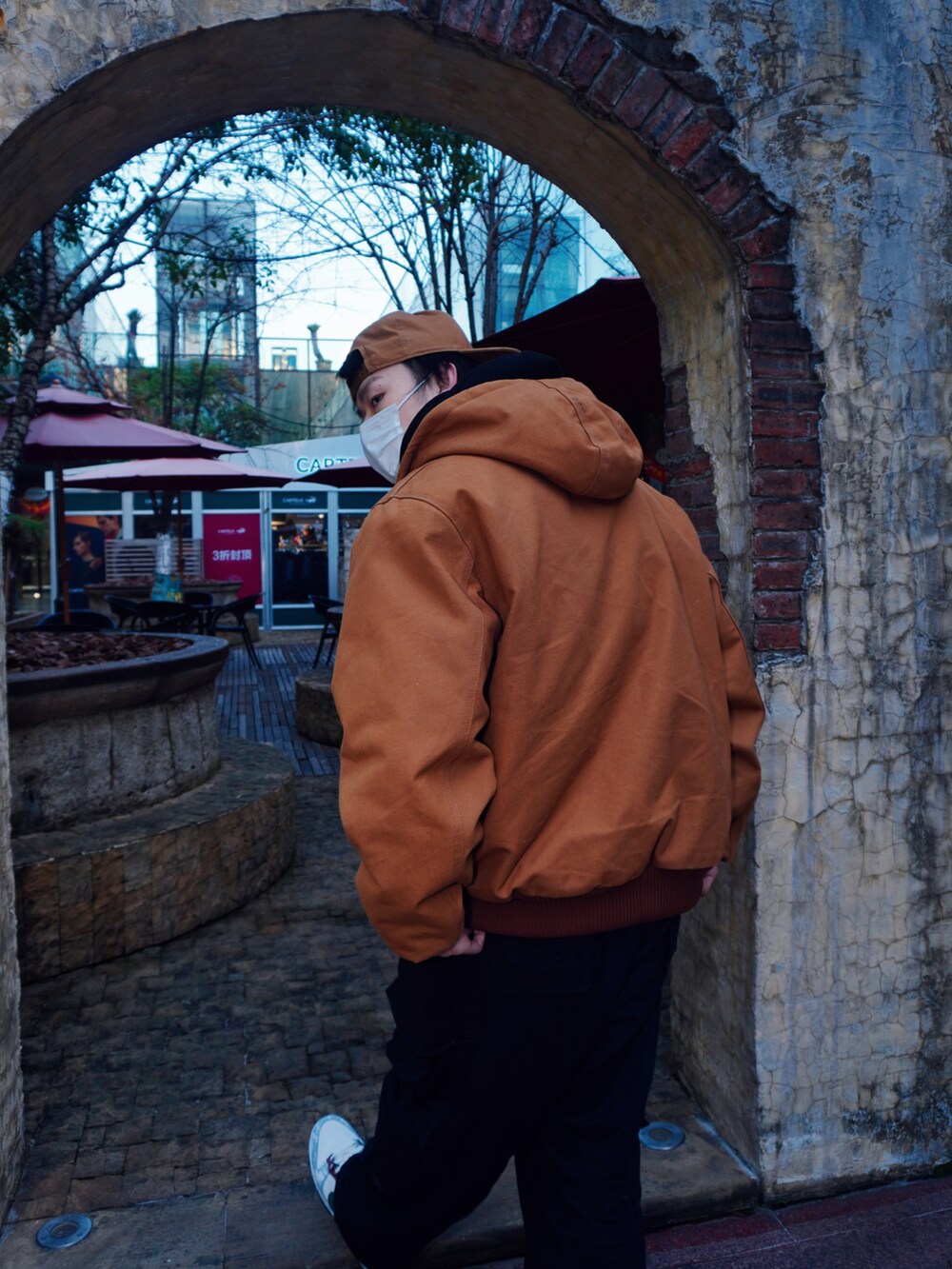 ブラック系のマウンテンパーカー、ホワイト系のシューズ、ブラック系のキャップを着用したメンズの冬コーディネートの3枚目の写真