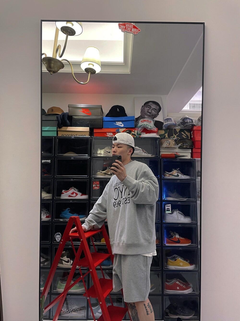 グレー系のパーカー、ブルー系のシューズ、ホワイト系の帽子を着用したメンズの春コーディネートの2枚目の写真