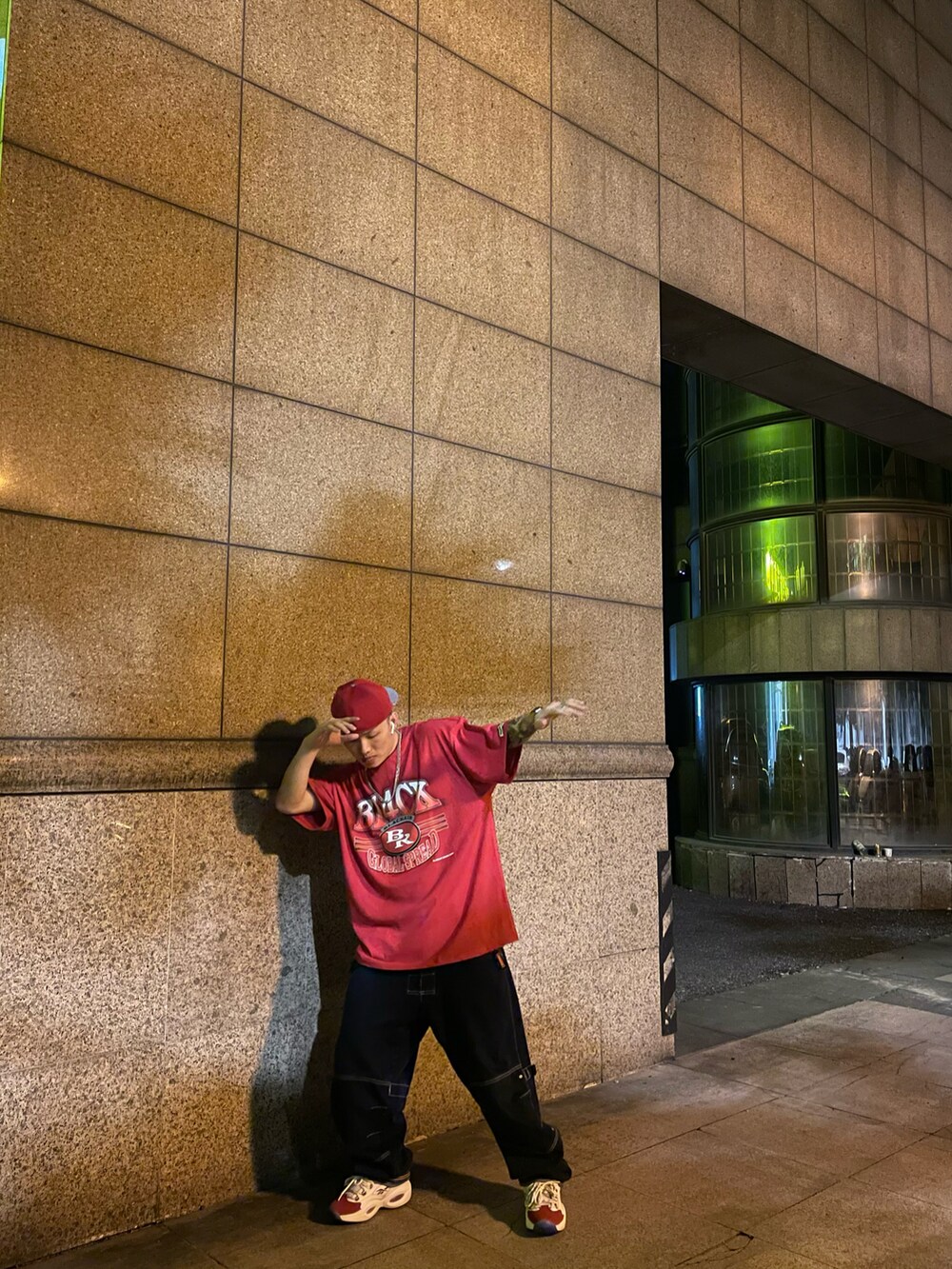 レッド系のスニーカー、ブルー系のデニムパンツ、レッド系のTシャツ/カットソーを着用したメンズの春コーディネートの3枚目の写真