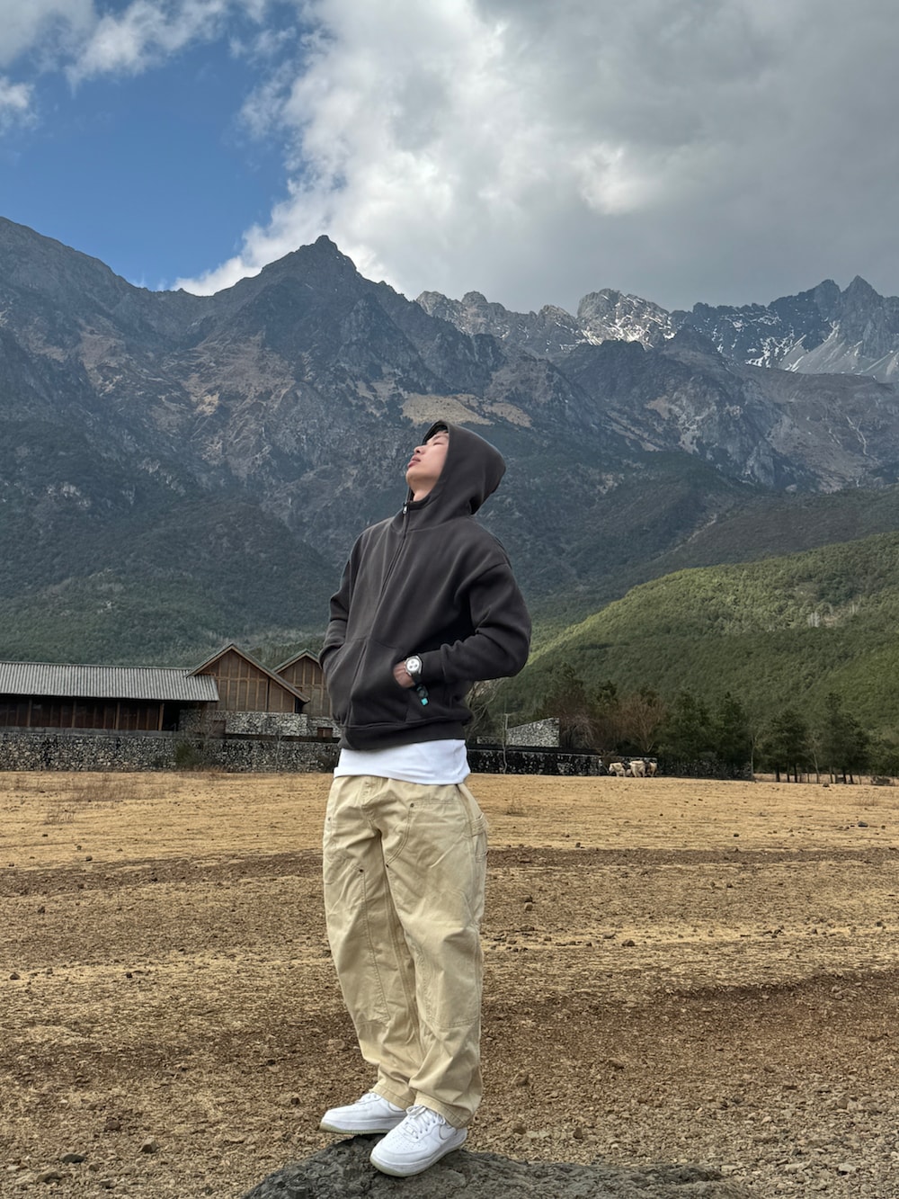 グレー系のスタジャン、ベージュ系のチノパンツ、ホワイト系のスニーカーを着用したメンズの春コーディネートの2枚目の写真